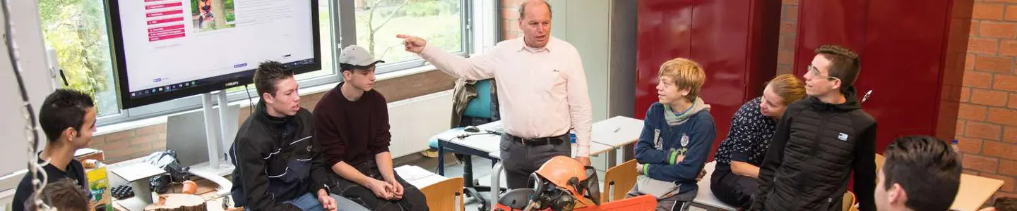 Een groep mensen zit rond een tafel en is verwikkeld in een ikdoehetmiddengeluid-gesprek. School en Veiligheid