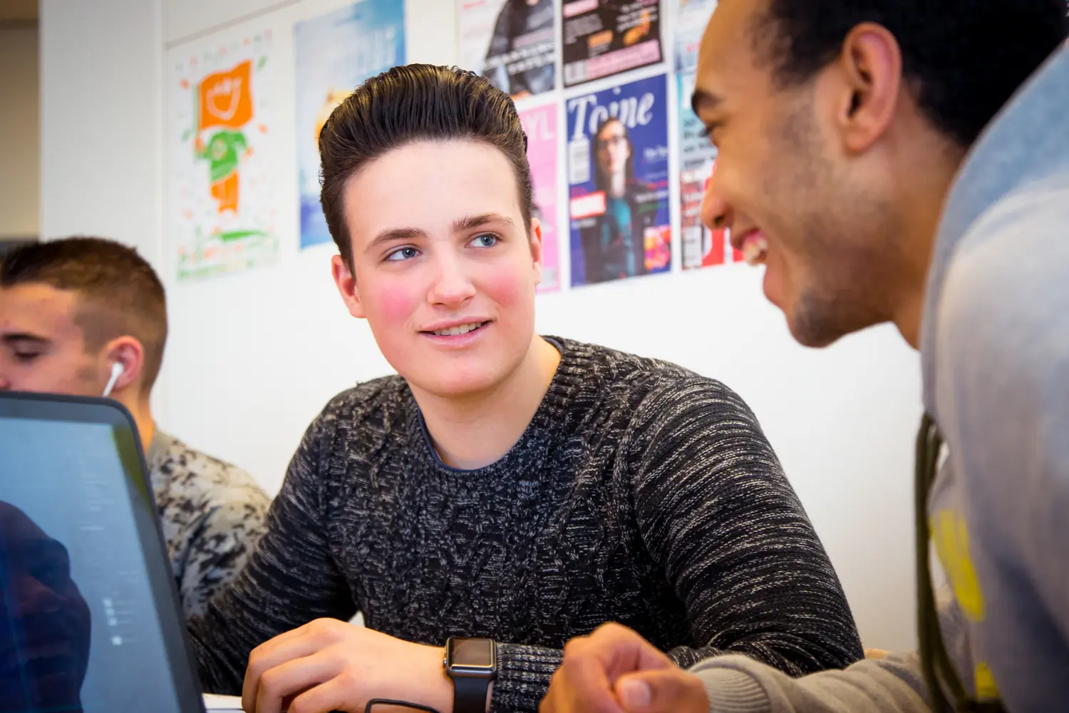         Een groep mensen aan de slag ontmoette elkaar inclusief zittend rond een laptop. School en Veiligheid