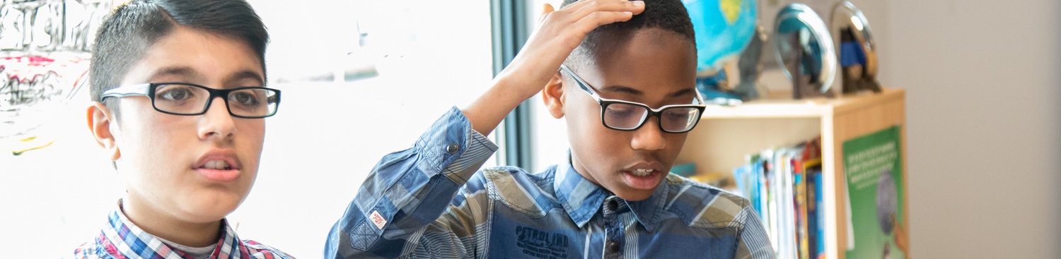 Een jongen met een bril kijkt naar zijn spiegelbeeld, terwijl hij afstandsleren doet. School en Veiligheid